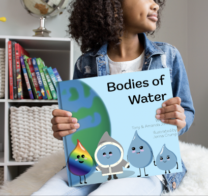 Young girl sitting on a fluffy bean bag holding the children's book 'Bodies of Water' and looking off camera.